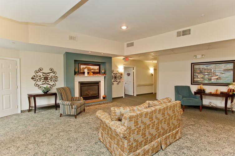 A cozy living room with a fireplace, featuring comfortable seating and elegant decor.