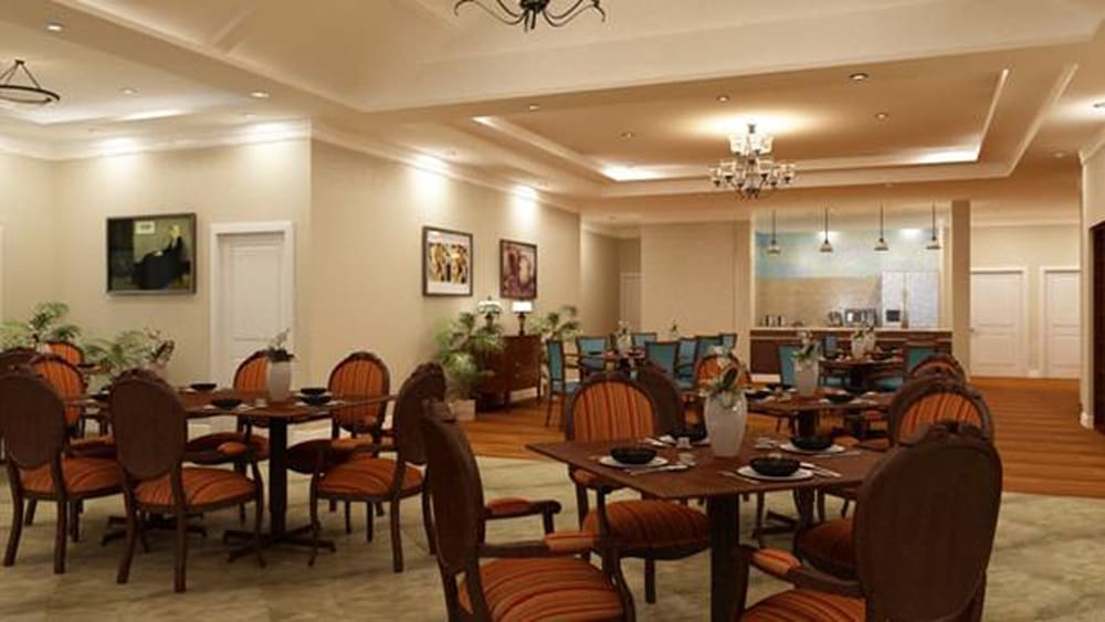 A cozy and elegant dining room with warm lighting, featuring classic furniture and neatly set tables.