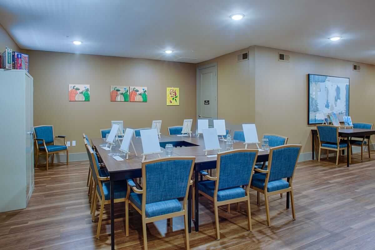 A modern conference room with a large table and chairs, featuring artwork on the walls.