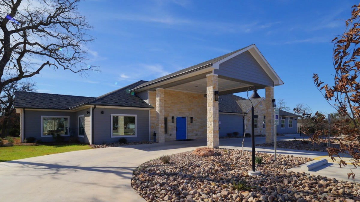 A modern house with a driveway under a clear blue sky.