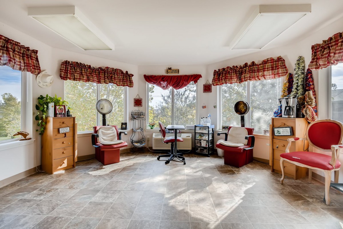 A bright and welcoming salon interior with chairs, hair dryers, and ample natural light.