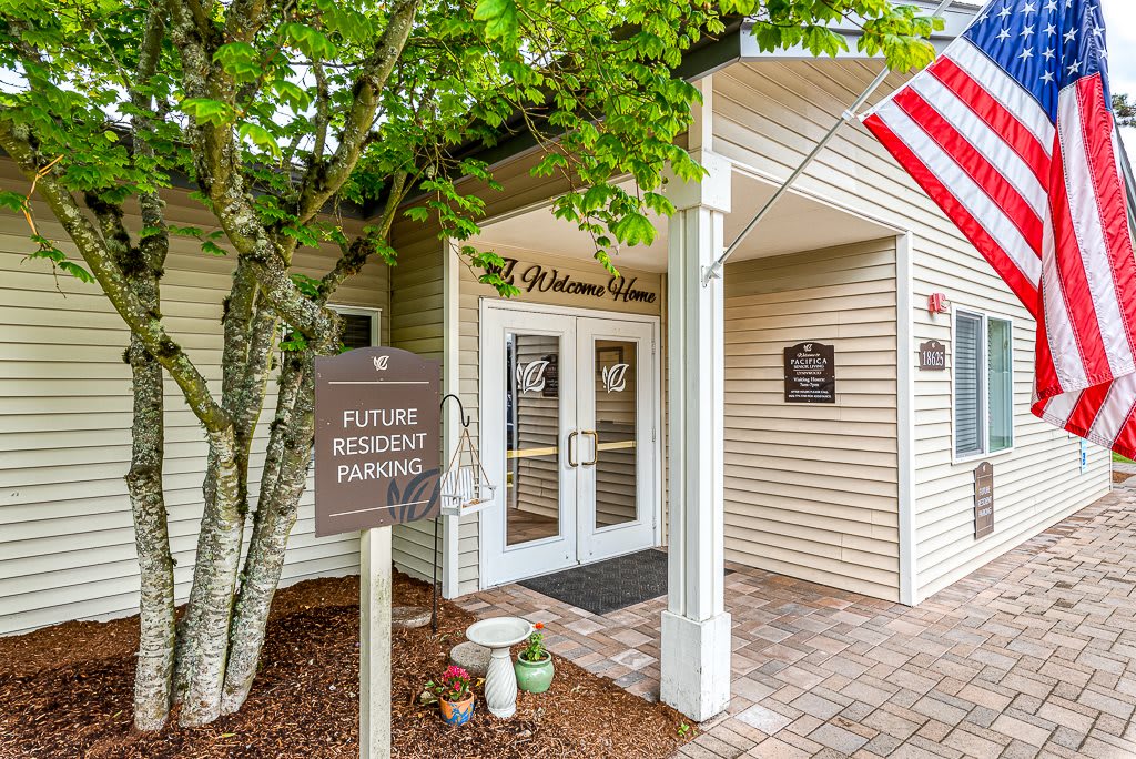 Entrance to a building with an American flag and a sign for future resident parking.
