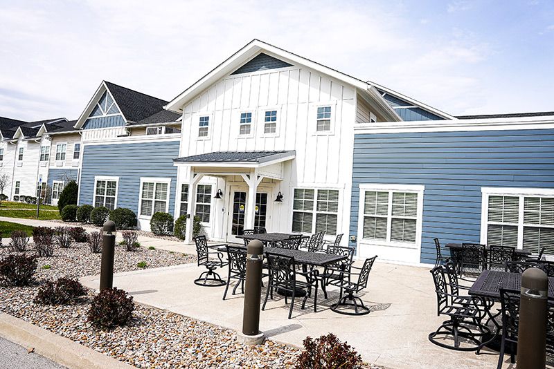A large house with blue siding and an outdoor patio area.