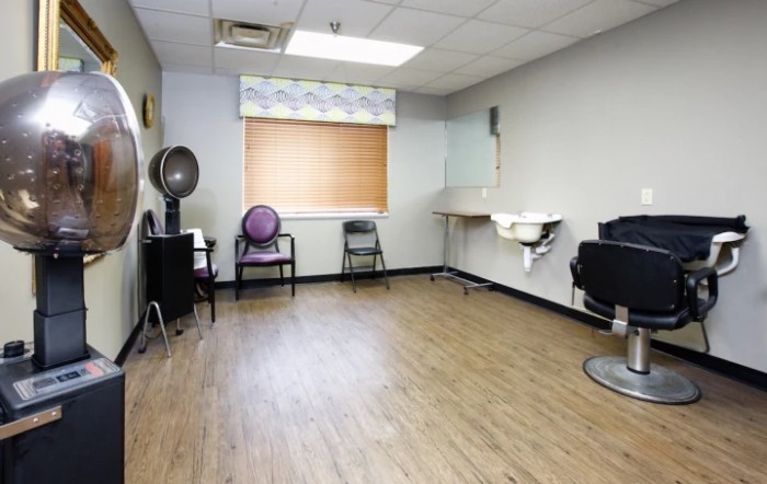 Empty salon room with hairdressing chairs and equipment.