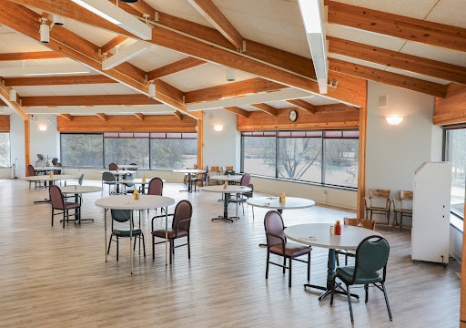 A spacious dining area featuring modern architecture with wooden beams and abundant natural light.