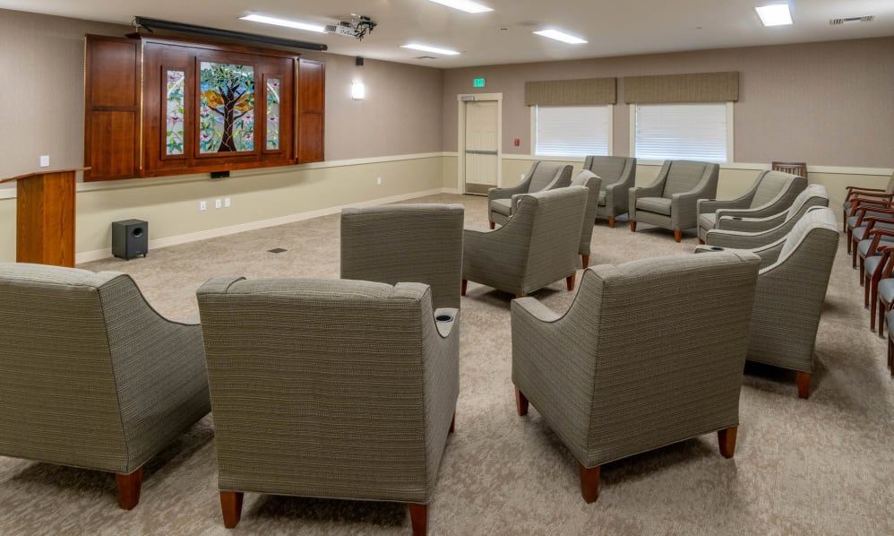 A cozy meeting room with arranged seating and a television.