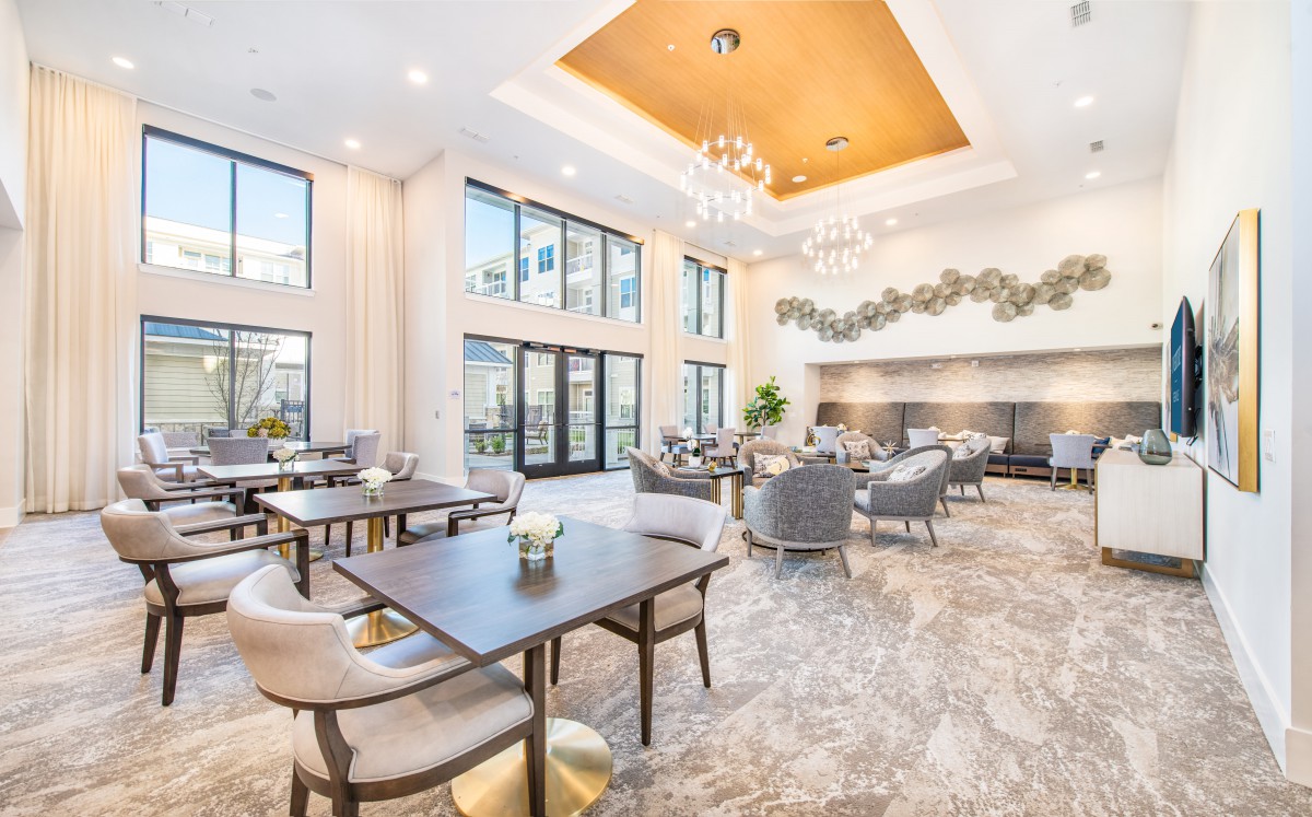 A modern lounge area with elegant furniture, large windows, and stylish chandeliers.