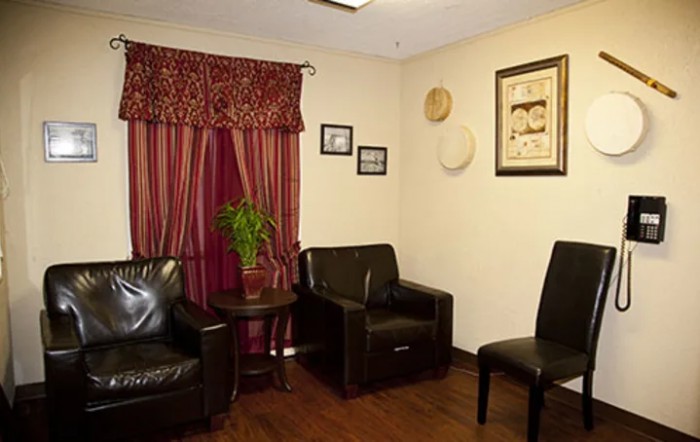 A cozy waiting room with leather chairs and wall decorations.