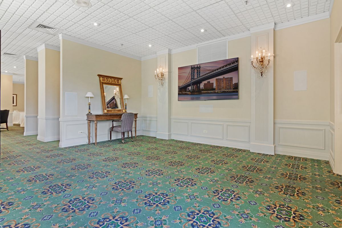 A spacious, elegantly decorated room with a mirror and artwork on the walls.