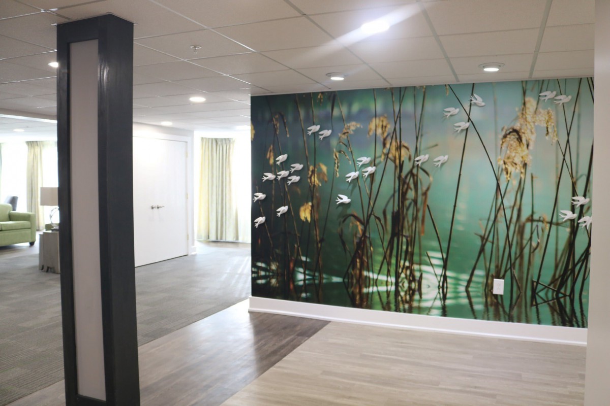 A modern hallway featuring a nature-themed wall mural with fish and plants.