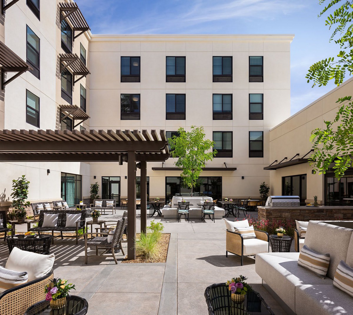 A modern hotel courtyard with comfortable outdoor seating and lush greenery.