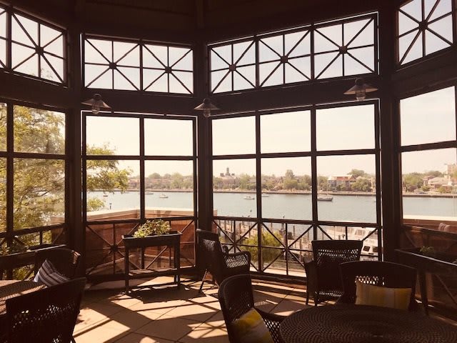 A cozy cafe with large windows overlooking a serene lake view.
