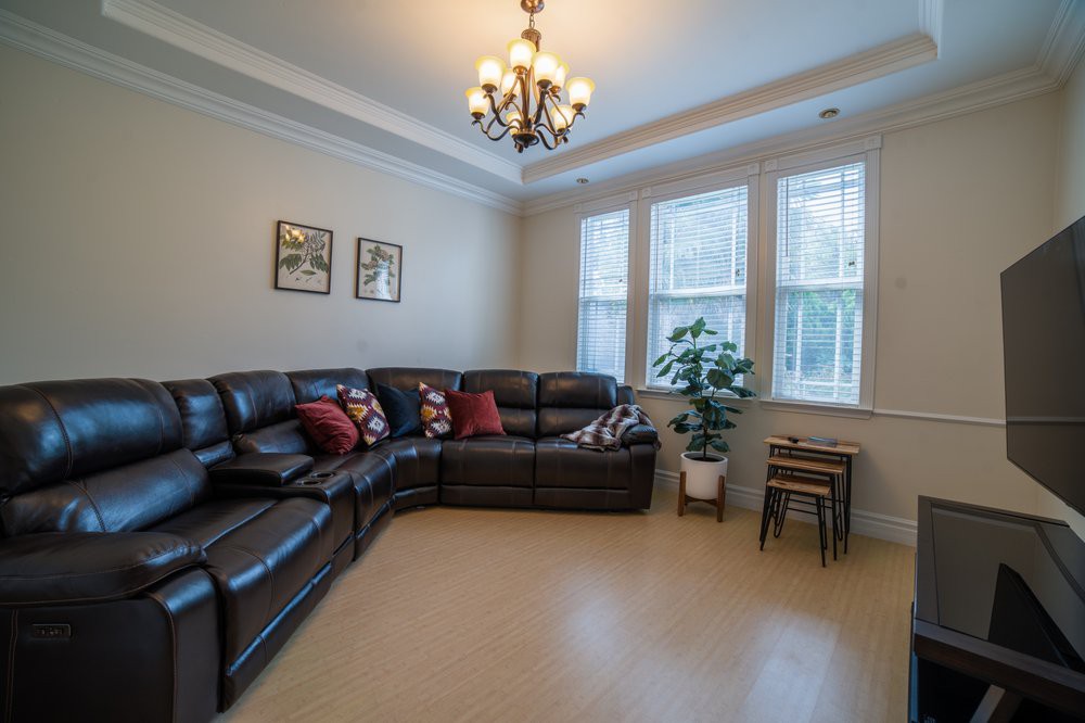 A cozy living room with a sectional sofa and a chandelier.