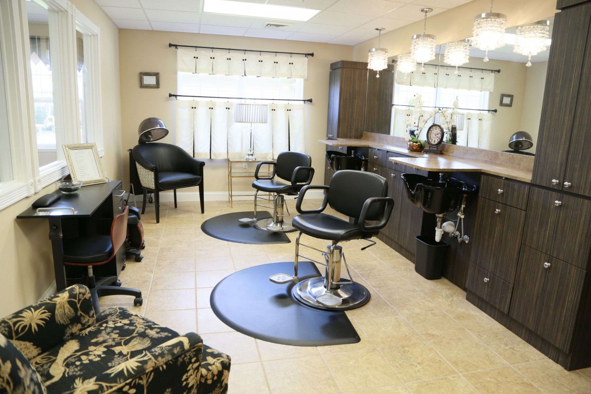 Modern hair salon interior with barber chairs and mirrors.