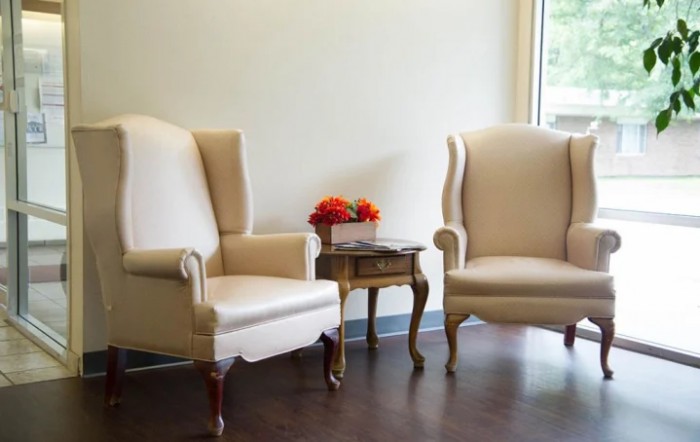 A cozy seating arrangement with two armchairs and a small table adorned with flowers.