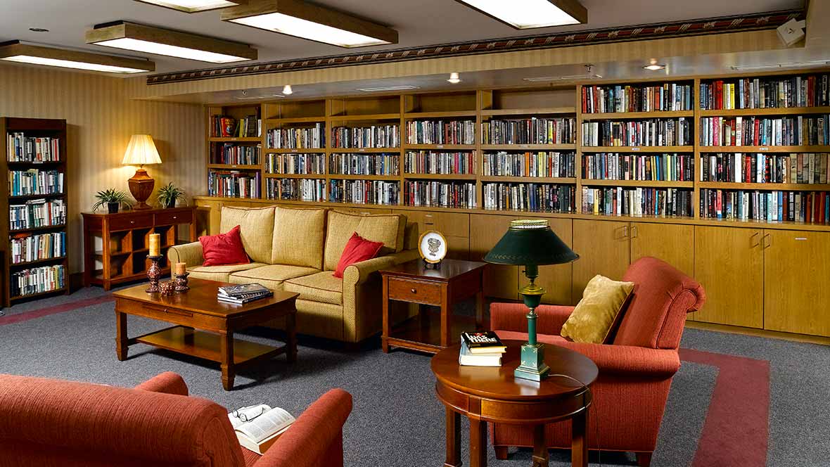 A cozy living room with bookshelves and comfortable seating.