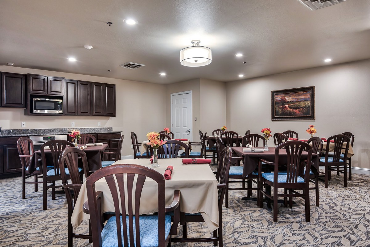 A cozy dining room with neatly arranged tables and chairs, ambient lighting, and elegant decor.