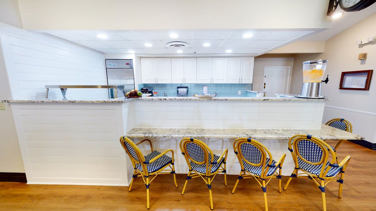 A modern kitchen with a granite countertop and stylish bar stools.