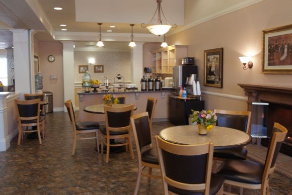 A cozy cafe interior with tables, chairs, and a coffee station.