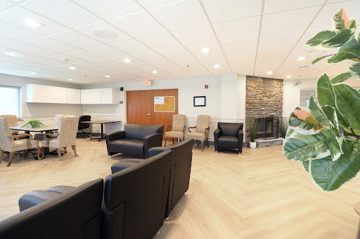 A modern lounge area featuring comfortable seating and a cozy fireplace.