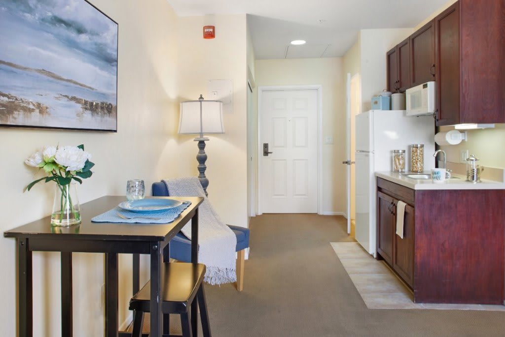 A modern apartment interior featuring a kitchenette and dining area.