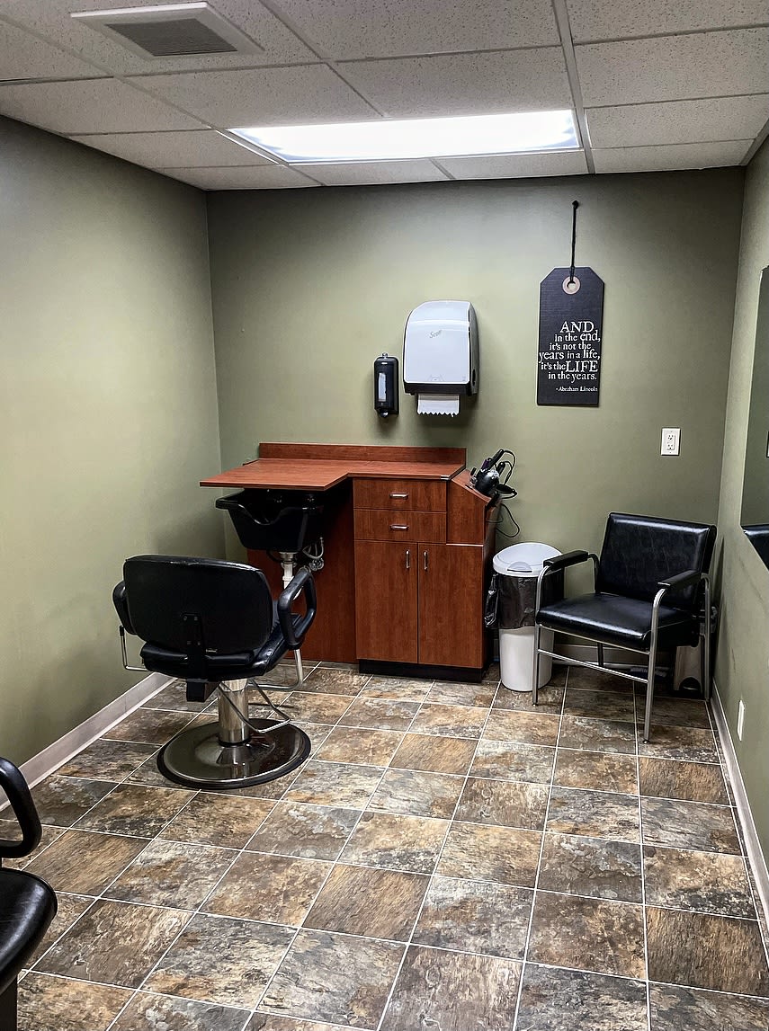 A small hair salon room featuring a barber chair and a waiting area.