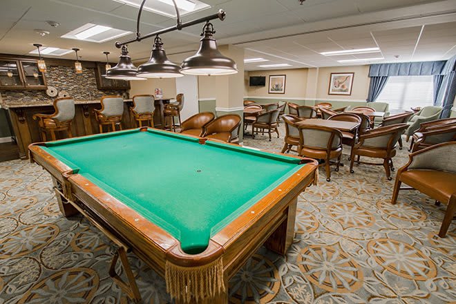 A well-furnished game room featuring a pool table and seating area.