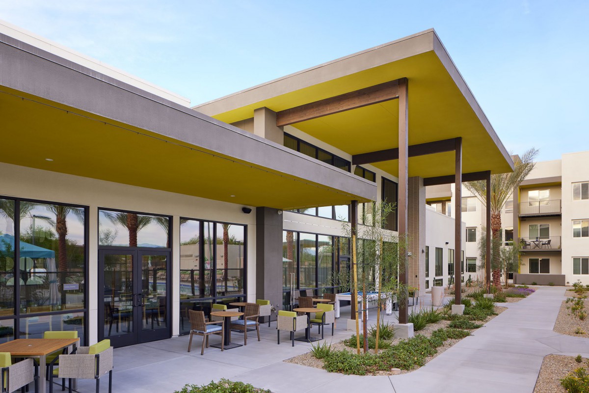 Modern building with a distinctive yellow roof and outdoor seating area.