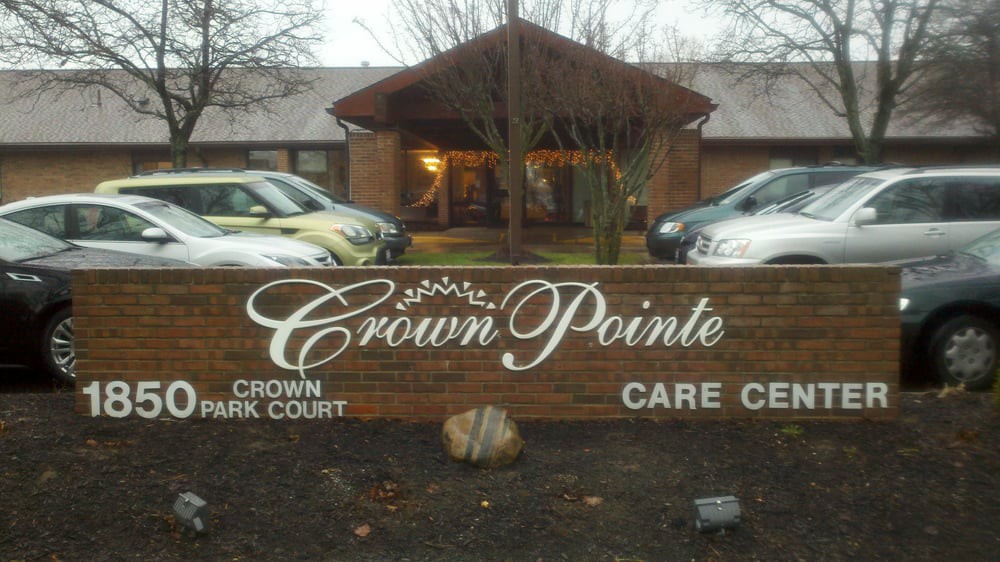 The image shows the entrance of the Crown Pointe Care Center with a prominent sign in front.