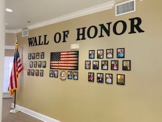 A Wall of Honor display featuring photographs of honored individuals alongside an American flag.