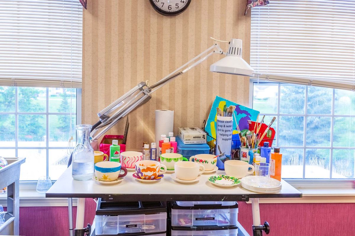 A well-organized craft table filled with various art supplies including paints, brushes, and colorful materials.