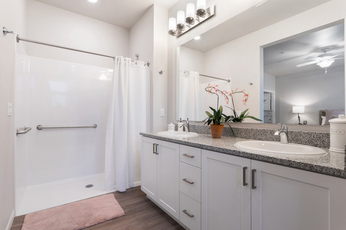 Modern bathroom with a spacious shower, elegant vanity, and bright lighting.