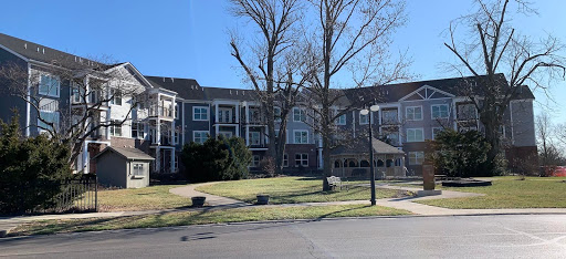 A view of an apartment complex surrounded by trees and clear blue skies.
