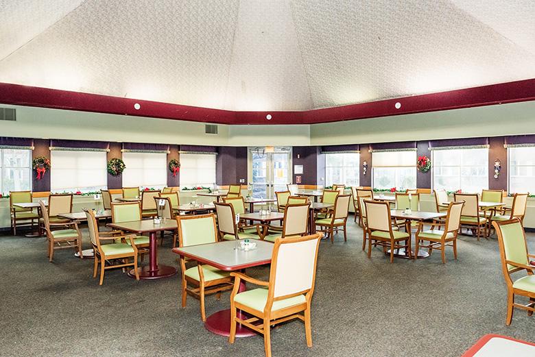 An empty restaurant dining area with neatly arranged tables and chairs.