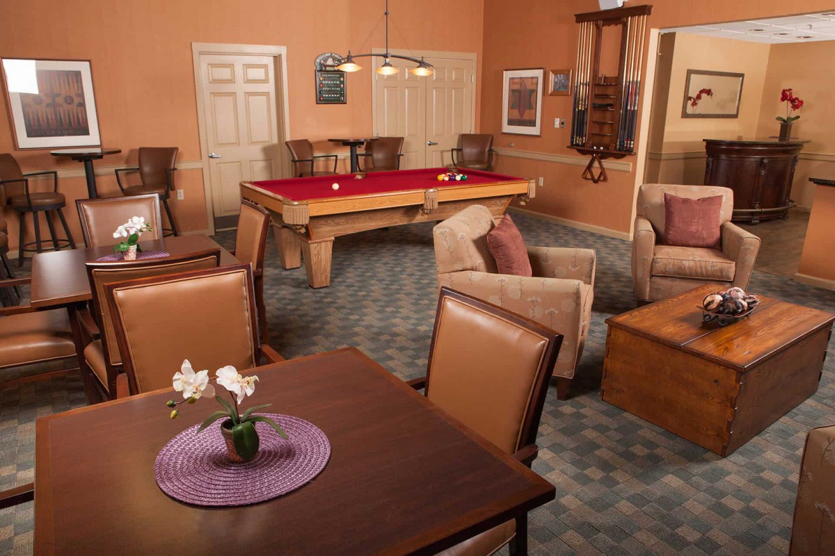 A cozy game room with a pool table and comfortable seating.
