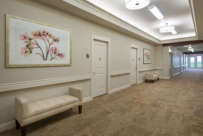 A well-lit hallway with benches and decorative artwork on the walls.