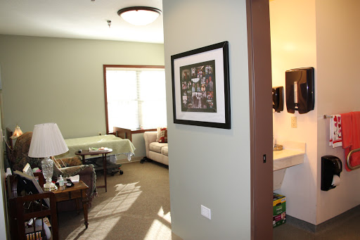 A view of a cozy living room with natural light, featuring a doorway and framed artwork on the wall.