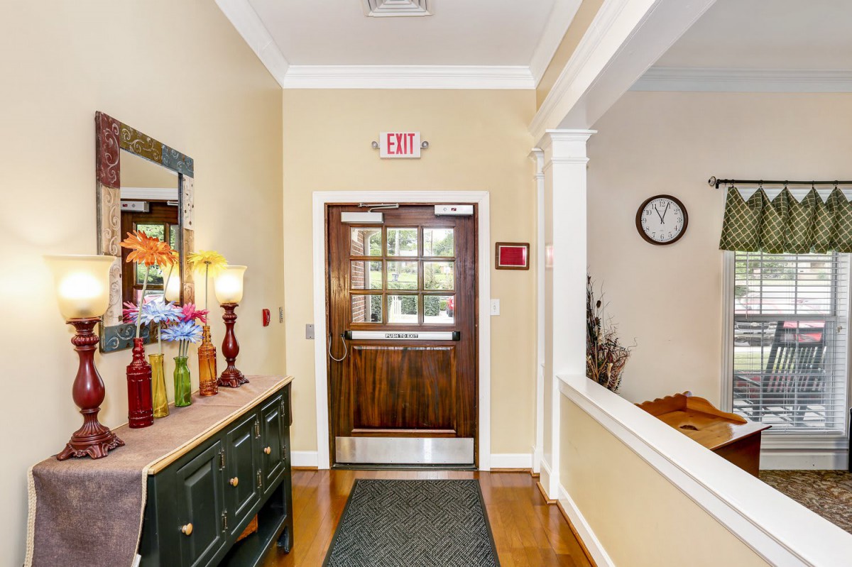 A well-decorated entrance hall with a wooden door and a wall clock.