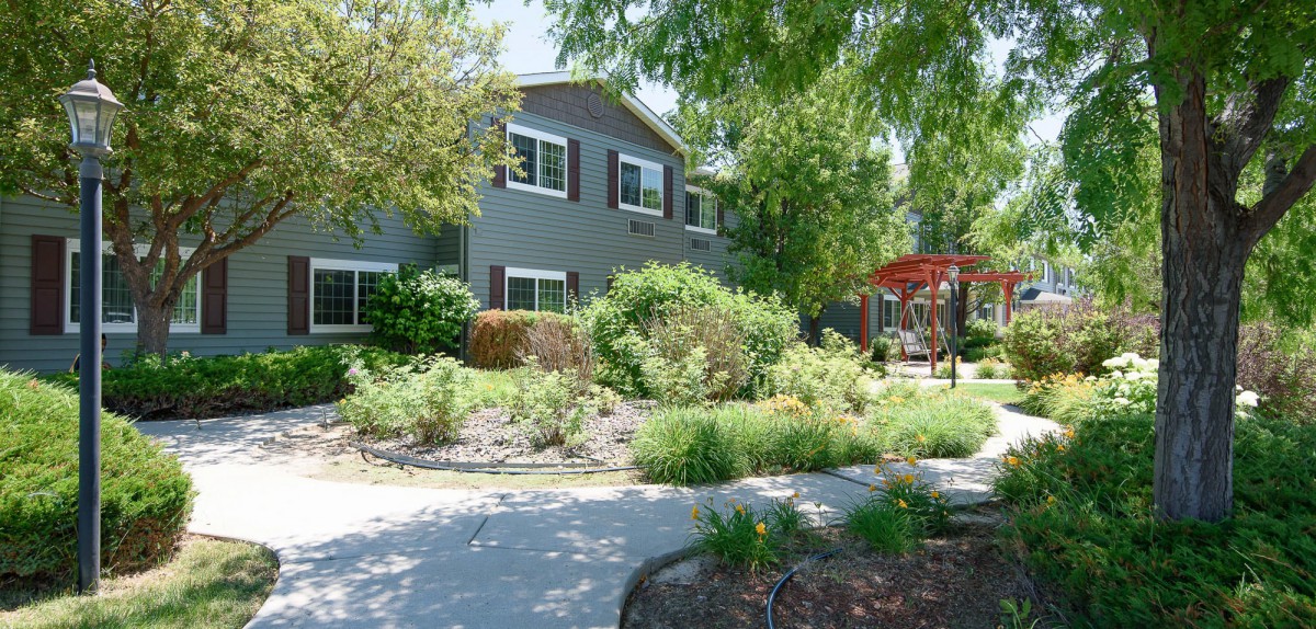 A suburban house with a beautifully landscaped garden and driveway.