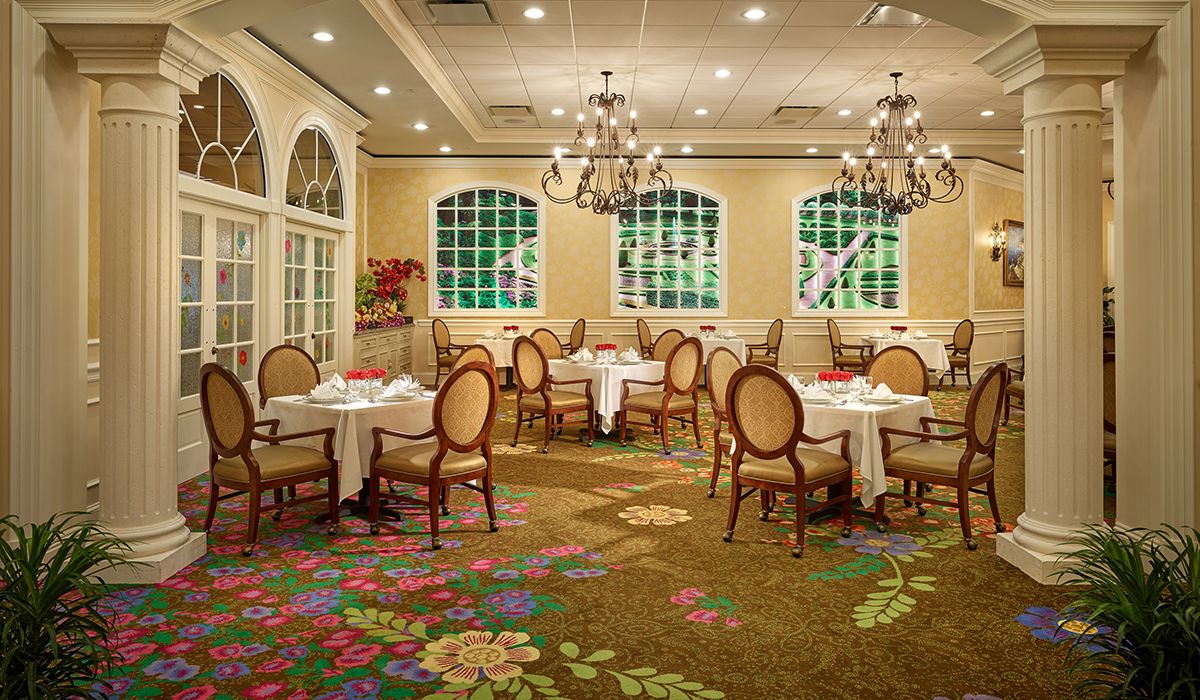 An elegant restaurant dining room with chandeliers and well-arranged tables and chairs.