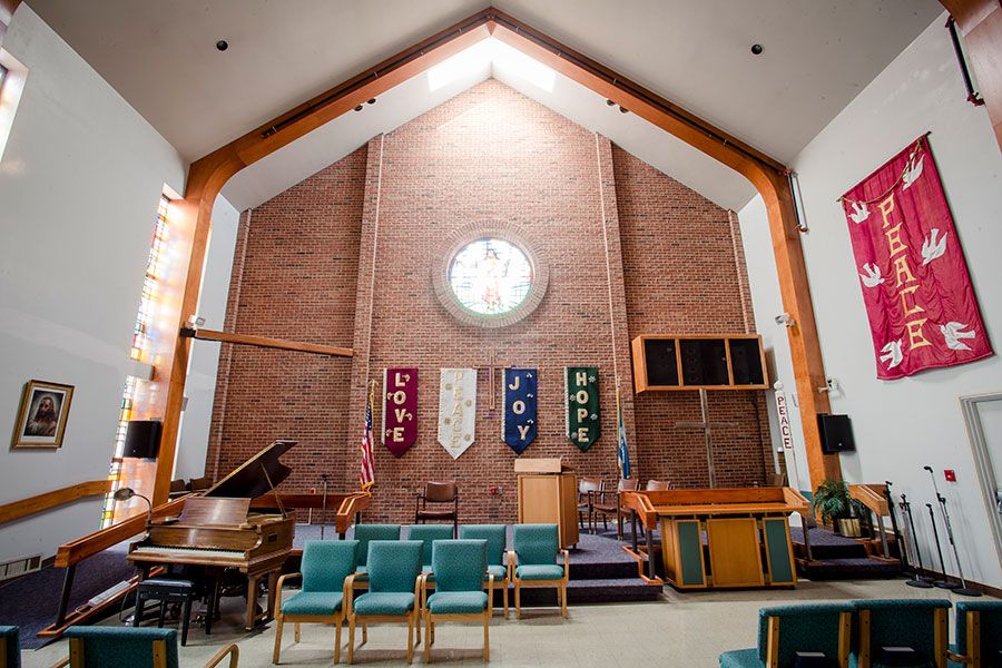A church sanctuary featuring a pulpit, banners, seating, and musical instruments.