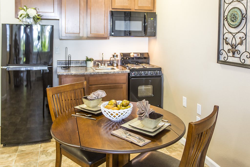 A cozy kitchen setup with a dining table surrounded by chairs and modern appliances.