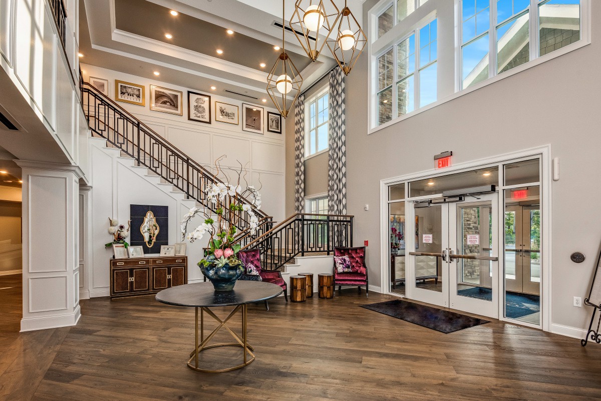 A spacious and elegantly designed lobby with a grand staircase and modern decor.