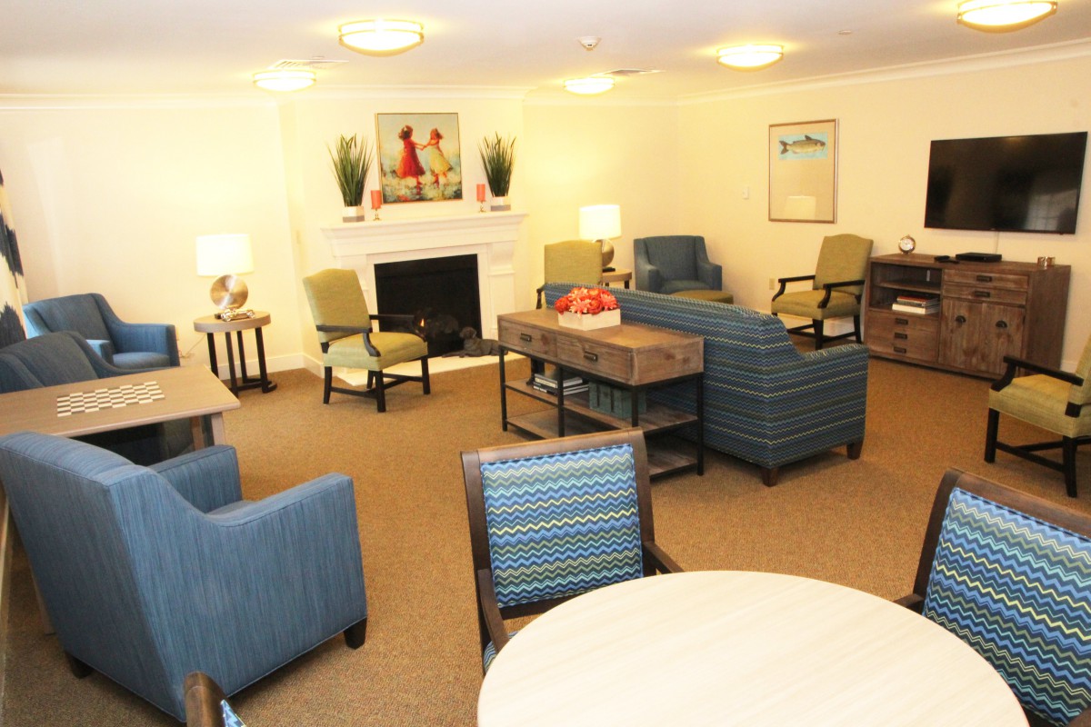 A cozy living room with several chairs and a coffee table arranged around a fireplace.