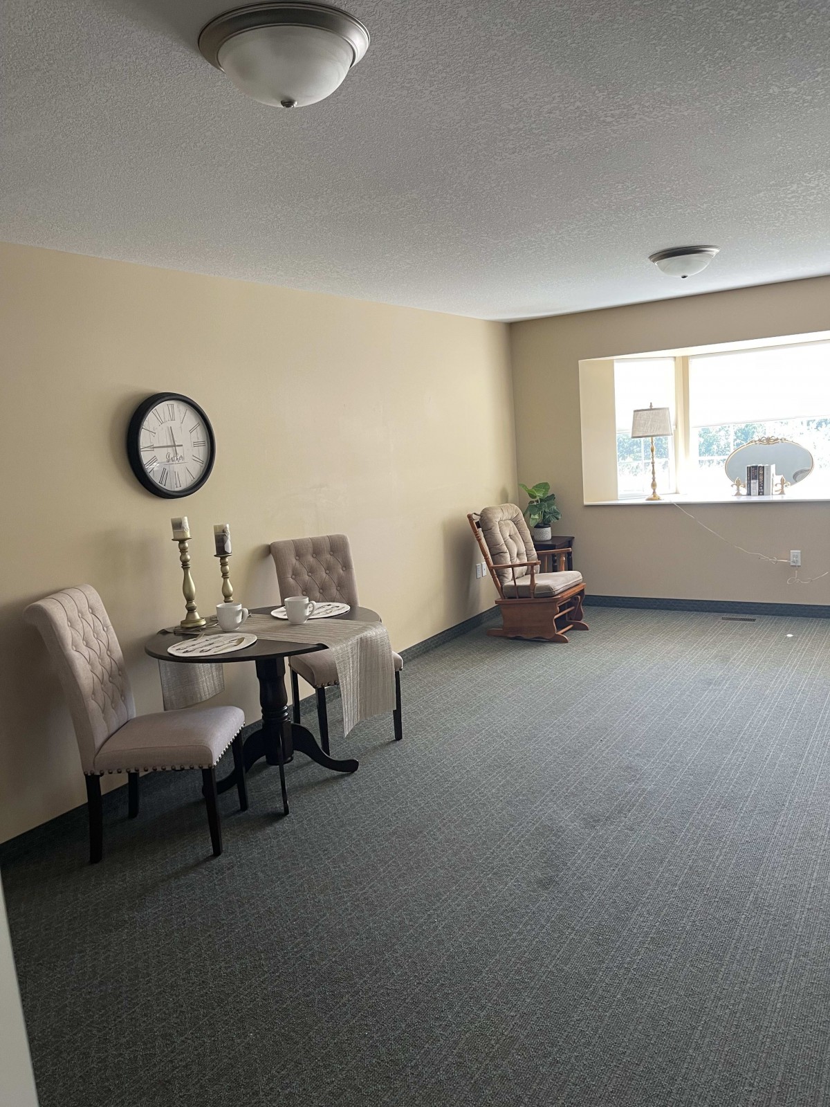 A cozy living area with chairs, a small table, and a large window.