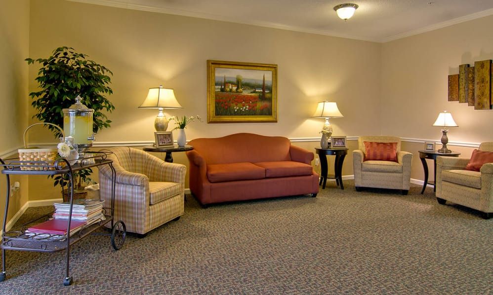 A cozy living room setup with sofas, armchairs, and warm lighting.