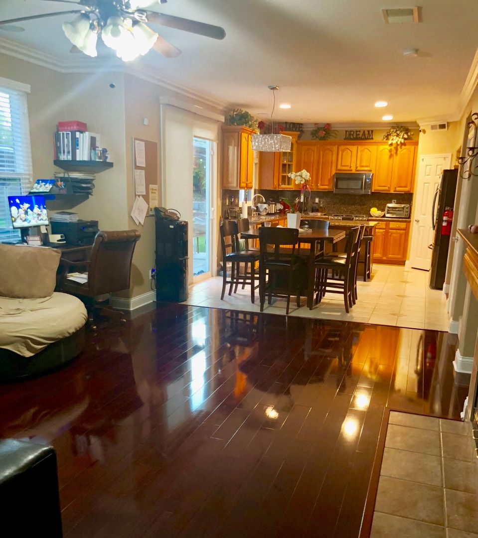 An open concept living area featuring a cozy living room, dining space, and kitchen with warm wooden accents.