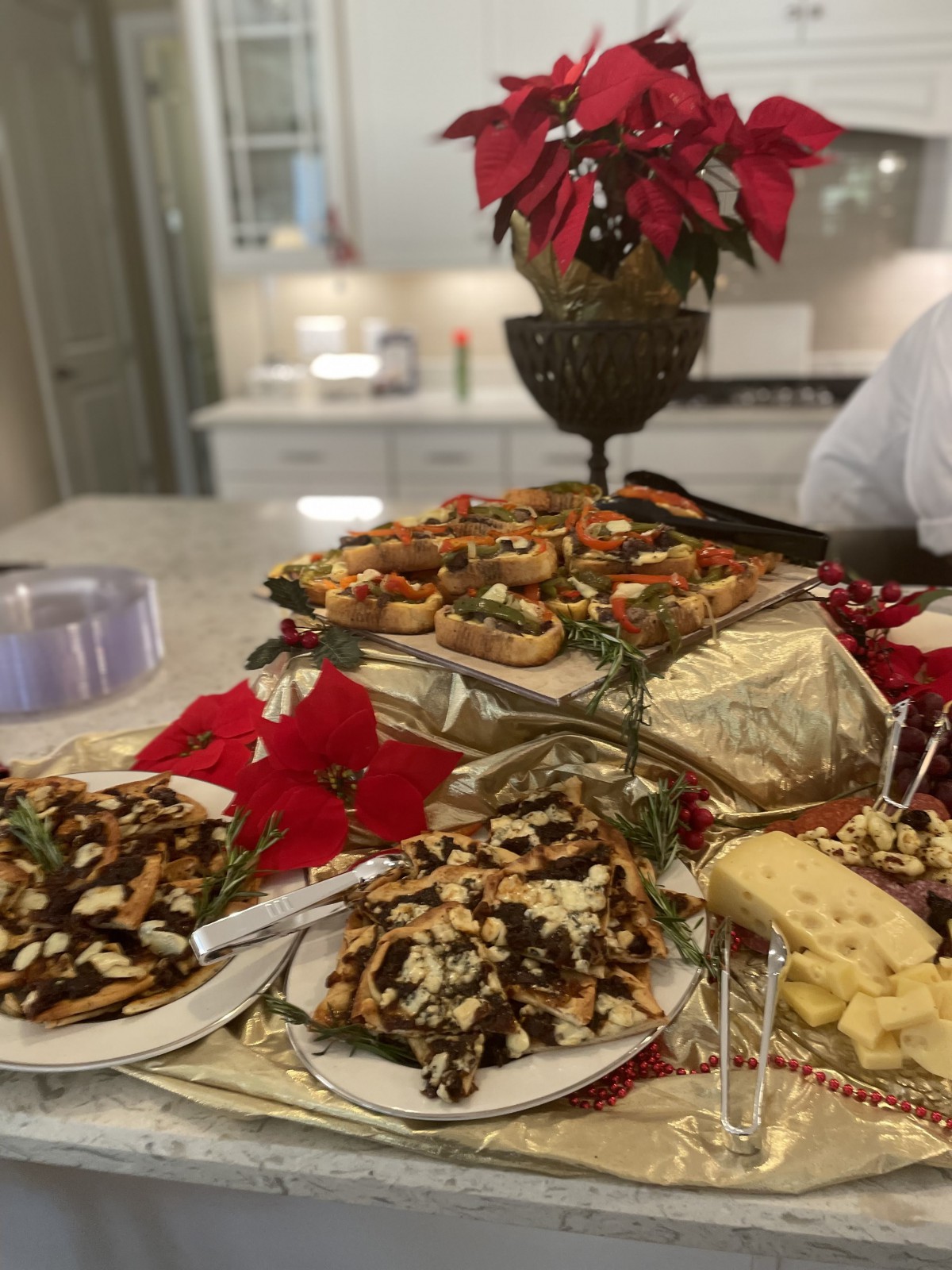 A festive holiday spread with appetizers, cheese, and decorative poinsettias.
