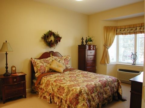 A cozy bedroom with floral bedding and soft yellow walls.