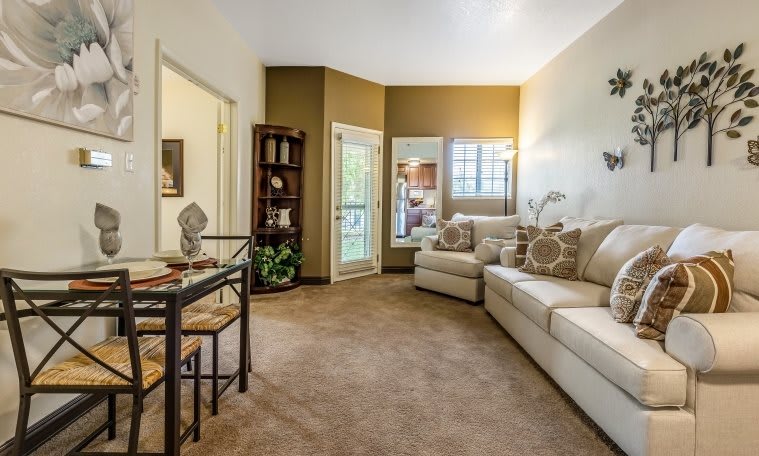A cozy living room featuring a large sofa, decorative pillows, and a bookshelf.